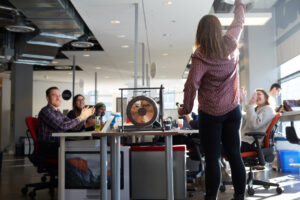 a group of DMZ startup founders celebrate a big win by hitting a gong